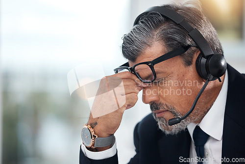 Image of Stress, sales and man in a call center with a headache from telemarketing or technical support. Sad, fail or a mature customer service employee or boss with a mistake or problem with communication