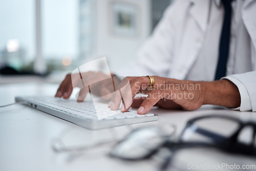 Image of Hands, keyboard and doctor typing at desk for research, healthcare and telehealth on internet in hospital. Computer, fingers and medical professional writing email, planning and work online in clinic