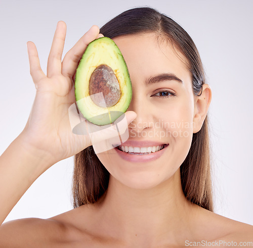 Image of Face, skincare and woman smile with avocado for beauty cosmetics isolated on a white background in studio. Portrait, happy and natural model with fruit food for nutrition, healthy diet or wellness