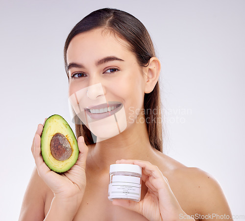 Image of Skincare, portrait and a woman with avocado or cream on a studio background for dermatology wellness. Happy, health and a young girl or model advertising a food or detox facial product for beauty