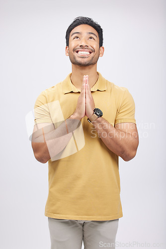 Image of Man, prayer hands and studio with looking up, smile and communication with God by white background. Student, praying and mindfulness with religion, gratitude and worship for peace, hope or meditation