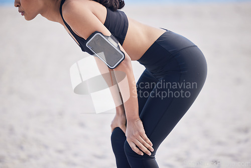 Image of Woman, fitness and break on beach after workout, running exercise or outdoor cardio training. Hands and body of fit, active and sporty female person in rest from intense exercising on the ocean coast