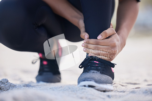 Image of Fitness, ankle pain and running with woman on beach for sports injury, inflammation and accident. Emergency, healthcare and muscle with closeup of runner for exercise, physical therapy and workout