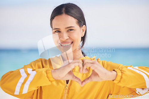 Image of Happy woman, portrait and heart hands on beach for love, care or support in trust, health or romance. Outdoor female person with emoji, symbol or icon for like or wellness in peace, sign or emoticon