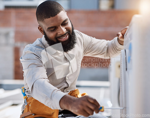 Image of Building, engineer and air conditioner install with a black man on a roof for construction or manual labor. Industrial, engineering and an electrician working on ac repair for maintenance or service