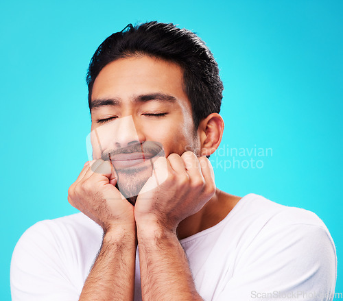 Image of Sleeping, dreaming and man face in studio with memory, relax smile and thinking to remember. Isolated, blue background and happy Indian male model with eyes closed for rest and nap feeling thoughtful