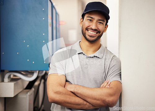 Image of Engineer, happy portrait and a repair man at work for maintenance, service and inspection control. Male technician with arms crossed and a smile in a room for machine, engineering or power supply