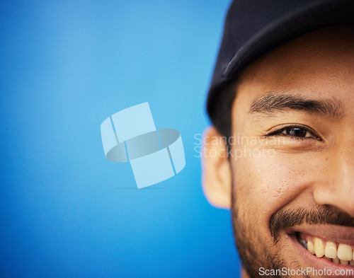 Image of Studio, portrait and closeup on half of man in sports on blue background with advertising, mockup or space with athlete. Happy, face and smile with cricket or baseball cap and fitness or wellness