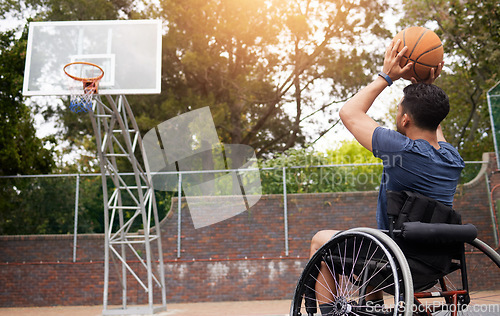 Image of Sports, basketball and man in wheelchair shoot for playing competition, challenge and practice outdoors. Fitness, goals and male person with disability with ball for training, workout and exercise