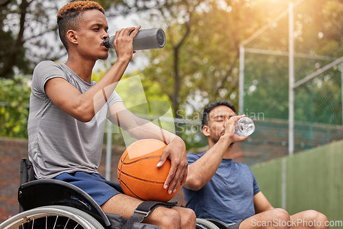Image of Men in wheelchair, basketball players or drinking water for sports break, rest or court fitness electrolytes. People with a disability, athletes or workout friends with bottle for exercise recovery