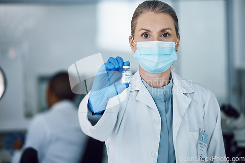 Image of Portrait of woman doctor with face mask and vaccine bottle in hand at hospital laboratory for covid research. Healthcare, medicine and medical professional with sample for corona vaccination in lab.