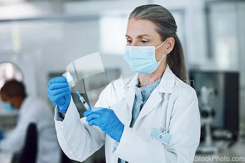 Image of Woman doctor, scientist with mask, needle and vaccine bottle at hospital laboratory for covid research. Healthcare, medicine and medical professional with sample syringe for corona vaccination in lab