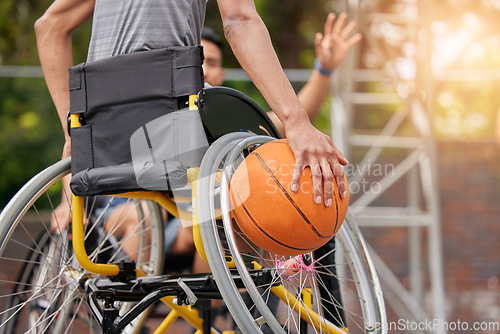 Image of Sports ball, wheelchair basketball and hands of person playing match competition, challenge or attack on outdoor court. Player, commitment and back of athlete with disability, training and exercise