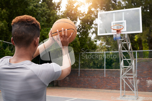 Image of Man, basketball and net outdoor to score points, winning and aim for target from the back. Player, court and athlete prepare to throw ball in hoop for fitness, sports games and competition training