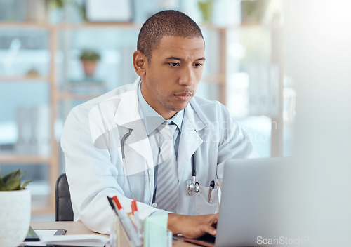 Image of Doctor, man and typing on laptop in clinic for hospital management, healthcare research and telehealth. Male medical worker at computer for professional review, online services and medicine analysis