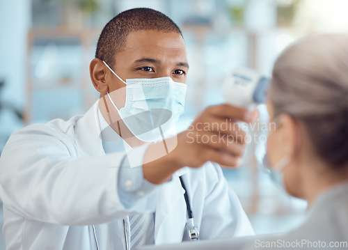 Image of Doctor in face mask, patient and thermometer in office for covid test, safety and healthcare in hospital consultation. Temperature check, corona and woman at clinic with medical professional for exam