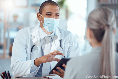 Image of Tablet, face mask and doctor consulting a patient in a health conversation or communication during medical consultation. Medicine, healthcare and professional talking to person for results in clinic