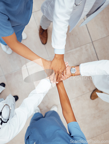 Image of Motivation, teamwork or hands of doctors in hospital for healthcare goals, unity or solidarity together. Clinic, top view or medical nurses with group support, trust or wellness mission in clinic
