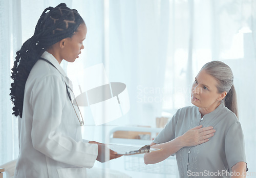 Image of Healthcare, discussion and doctor with elderly patient talking about chest pain problem. Consultation, clipboard and female medical worker speaking to senior woman with heart sickness in the hospital