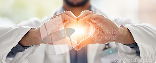 Image of Medical, light and doctor heart hands for love, support and healthcare in a hospital or clinic by medicine professional. Trust, hope and worker with bright sign, symbol or gesture for cardiology