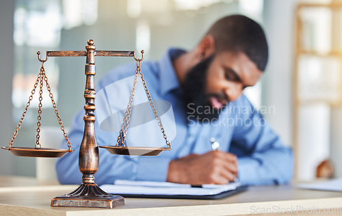 Image of Scale, notes and black man in office, lawyer or judge at desk with paperwork, research or crime report. Justice, icon and attorney at law firm writing in notebook, legal administration and contract.