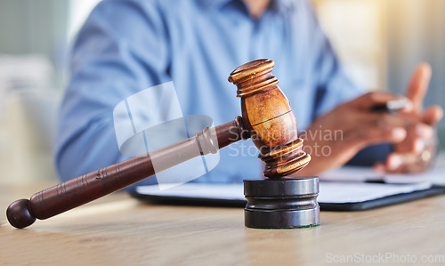 Image of Closeup, lawyer and gavel of judge in office of trial, attention and meeting for justice in courtroom, law firm or table. Hammer, legal tool or attorney working at desk for consulting of constitution