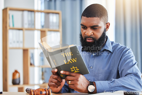 Image of Man, reading and lawyer with a book on the law, rules or research on legal constitution, regulation or policy from government. African businessman, judge or attorney with knowledge of justice