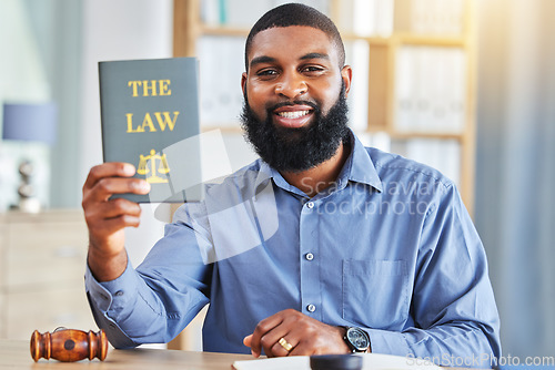 Image of Happy, man and portrait with a book on the law, rules or research on legal constitution, regulation or policy from government. African businessman, lawyer or attorney with knowledge of justice
