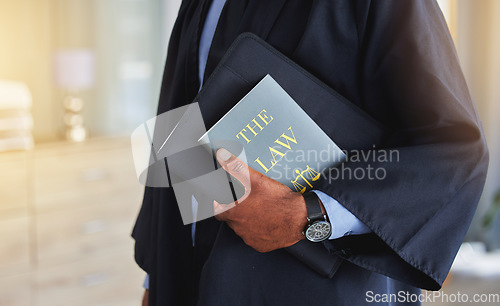 Image of Law, book and hands of a judge with knowledge on the rules or research of legal constitution, regulation or policy from government. Black man, lawyer or expert attorney of court justice and judgment