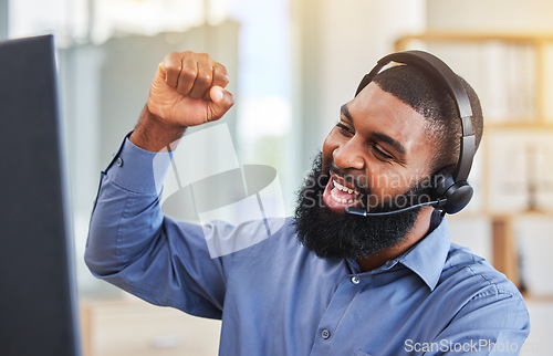 Image of Call center, success and business man, winner or consultant for target, sales and telemarketing celebration on computer. Professional agent or african worker yes, cheers and fist for telecom goals