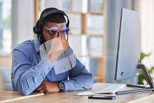 Image of Call center, man and headache, pain or stress for communication mistake, error and sales crisis on computer. Agent, consultant or african person in glasses and computer with eye care in telemarketing