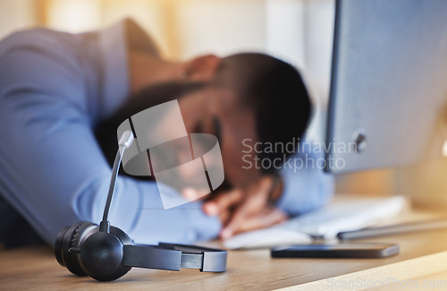 Image of Call center, tired and man sleeping with microphone at desk for burnout, fatigue and low energy in telemarketing office. Closeup, stress and business consultant taking a nap at table in sales agency