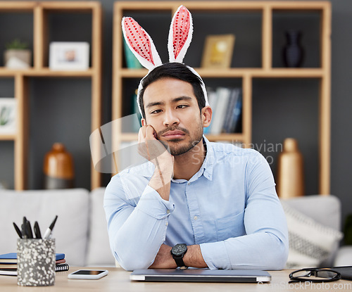 Image of Tired, bunny ears and business man for Easter in office with decoration for celebration, event and party. Burnout, stress and Asian male person with fatigue at desk with rabbit headband for holiday