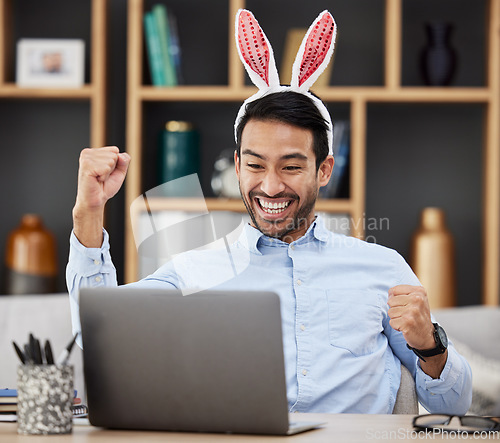 Image of Bunny ears, easter and winning by business man excited, happy and celebrate in an office with success. Winner, rabbit and employee or person with victory, achievement and using a laptop for profit