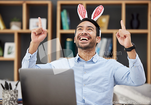 Image of Bunny ears, easter and celebration by business man excited, happy and winning in an office with success. Winner, rabbit and employee or person with victory, achievement and using a laptop for profit