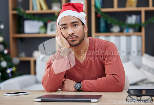 Image of Bored, christmas hat and exhausted man in the office while working on a creative project. Tired, burnout and young professional male designer with xmas decorations working in the modern workplace.