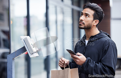 Image of Courier man, paper bag and city with phone, typing and delivery app with search in supply chain job. Young logistics worker, package and thinking with smartphone, product and ecommerce in metro cbd