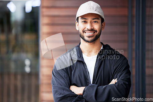 Image of Portrait, arms crossed and asian man courier outdoor for delivery and service with a smile. Face, proud and happy Japanese male carrier ready for ecommerce, order or logistics, mail or distribution