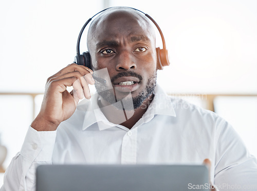 Image of Black man thinking while consulting on laptop in call center for customer service, advisory and questions. Face of serious salesman working in CRM agency for telecom solution, tech support and help