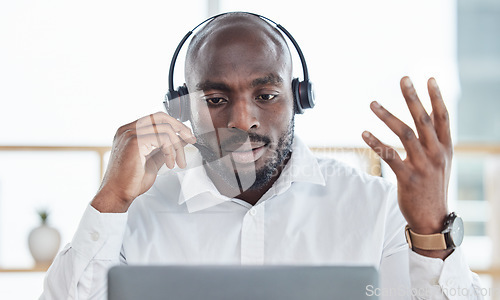 Image of Black man, laptop and business consulting in call center for customer service, advisory and questions. Face, serious salesman and working on computer in CRM agency for telecom support, FAQ or contact
