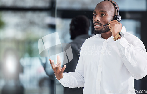 Image of Black man, microphone and consulting in call center for customer service, advisory help and FAQ questions. Serious salesman working in CRM agency for telecom solution, tech support and communication