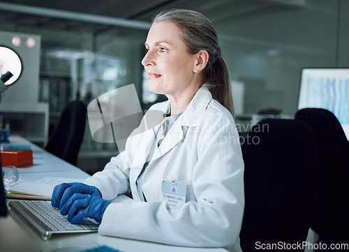 Image of Woman, night and keyboard in science laboratory for medical research, deadline and pharmacy wellness. Mature scientist, person and working late on technology for DNA healthcare or genetic engineering