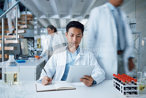 Image of Asian man, tablet and writing in science laboratory for medical virus research, medicine and vaccine development. Busy scientist, technology and notebook paper for blood sample healthcare or wellness