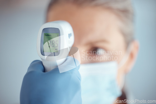 Image of Woman in face mask, hand of doctor and thermometer in hospital for covid test, safety and healthcare consultation. Temperature check, corona and patient at clinic with medical professional for exam.
