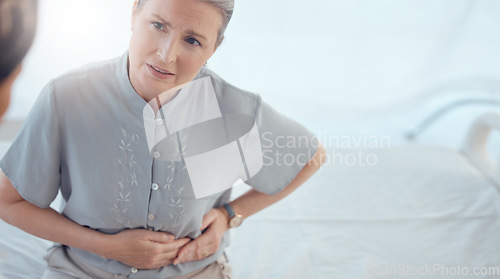 Image of Healthcare, senior and woman with a doctor and pain from the appendix for a consultation. Stomach pain, hospital and elderly clinic patient speaking to medical professional about an injury or problem