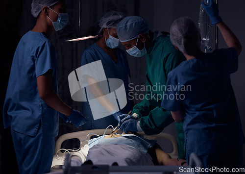 Image of Hospital surgery, teamwork and surgeon operation, emergency service or helping patient in healthcare dark room. Clinic support, operating theatre or doctors doing medical procedure on client at night