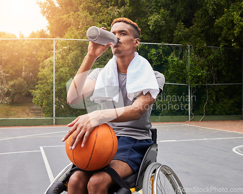 Image of Basketball player, drinking water or man in wheelchair for sports break, rest or fitness electrolytes on court. Person with a disability, athlete or bottle for recovery, exercise and workout wellness