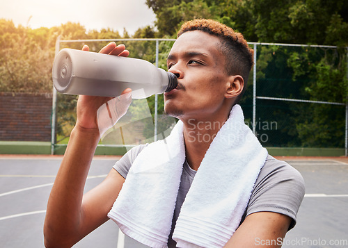 Image of Outdoor, fitness and man with water, training or body recovery with exercise, workout goal or tired. Healthy person, exhausted or African athlete with liquid, hydration or thirsty on court for sports