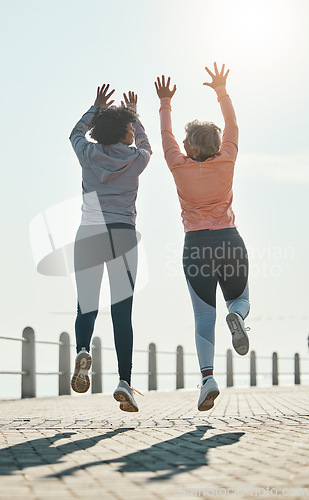 Image of Fitness, jump and success with friends at beach for celebration, motivation and training. Cardio, workout and health with mature women in nature for running, energy and exercise goals together