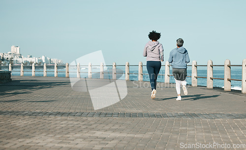 Image of Back view, beach and women running for fitness together as morning exercise for wellness and outdoor bonding. Health, endurance and people training for marathon in Cape Town for sports workout